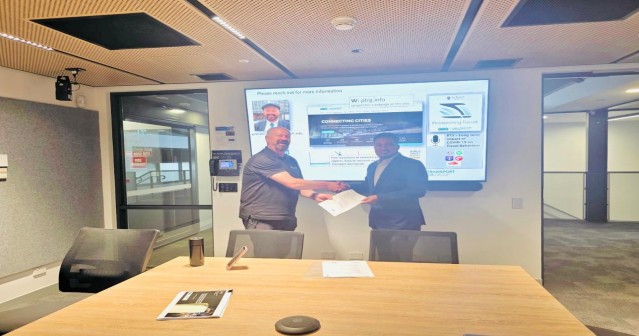 MoU handshake at Monash University with project presentation on screen